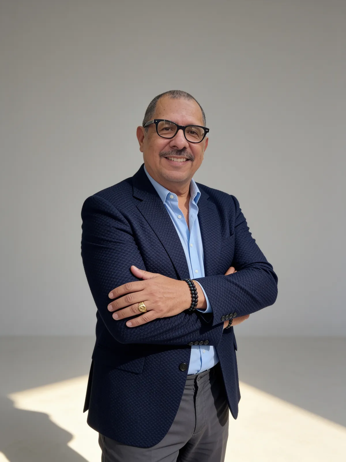 Álvaro Patiño con los brazos cruzados en un estudio de fondo claro